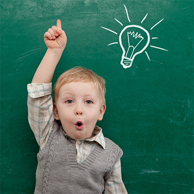 Little boy in front of blackboard